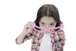 Who are you. Schoolgirl heart shaped glasses isolated white background. Child serious girl picking out of eyeglasses copy space. Child smart kid wondering face close up. Suspicious concept