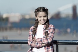 Girl cute kid with braids relaxing urban background defocused. Organize activities for teenagers. Vacation and leisure. What do on holidays. Sunny day walk. Leisure options. Free time and leisure