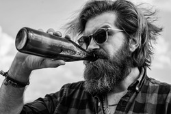 feeling thirsty. mature charismatic male drink beer from bottle. guy with beard and moustache outdoor. drinking beer from glass bottle. bearded man with water. get refreshed and relaxed