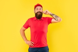 Happy man in casual red cap and tshirt twirling moustache yellow background, volunteer