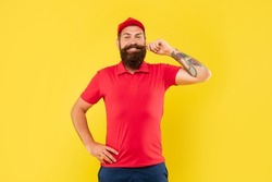 Happy man in casual red cap and tshirt twirling moustache yellow background, salesman
