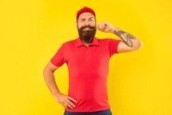 Happy man in casual red cap and tshirt twirling moustache yellow background, deliveryman