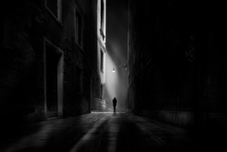 guy is walking along through dark city