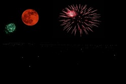 Fireworks and moon in the urban sky 