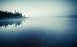 Quiet lake before dawn in the mist