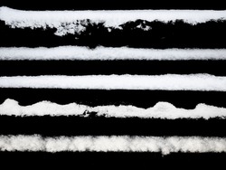 set of strips of white snow isolated on a black background. High quality photo