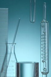 Assorted laboratory glassware equipment showcase with oil on Blue backround. Stage showcase cosmetics on glass pedestal modern in laboratory equipment. Minimal concept.