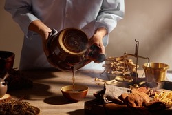 Traditional chinese medicine with herb and spices in brown wooden background doctor using a traditional kettle for advertising , chinese traditional content 
