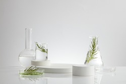 Science research on green leaf sample on beaker with fluid and petri dish with white podium in laboratory for develop , white background with glassware for laboratory advertising  