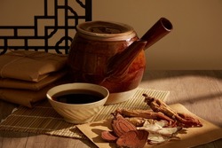 Tabletop herbal medicine vignette with Red Ginseng and finely cut dried mushrooms on the wooden table