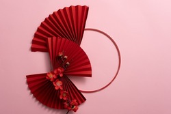 Stylish Red paper fan, circle, and red blossom, and on pink background. Chinese new year decoration. Traditional Japanese style. Wall decoration ideas.