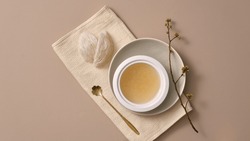 Top view of edible bird’s nest, a golden spoon and white bowl filled with bird’s nest soup, placed on napkin. High-quality dessert well-liked by women in Asia