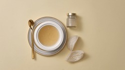 Top view of raw bird’s nest , bowl soup, and glass bottle without label on beige background. Mockup for products derived from natural bird's nest