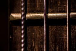 Sixth guitar string, metal string and metal fret in a wooden spanich guitar. Macro photography

