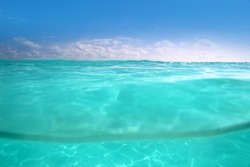 clear waterline caribbean sea underwater and over with blue sky horizon