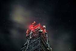 Tower for mobile communication systems 4g and 5g on the background of the starry sky. Cellular base station at night