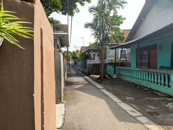 photo of a narrow street or alley in a village in Indonesia in the morning