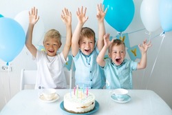 cute kids kids boys celebrate their birthday with blue balloons and a sweet birthday cake on a white background. Happy birthday, happy kids