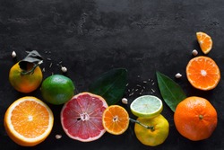 Fresh citrus fruits (orange, mandarin, lemon, lime, grapefruit) on a black background with place for text. concept vitamins for immunity