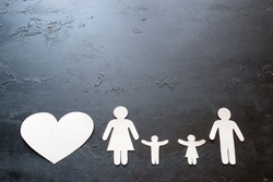 paper family and heart on a black background with space for text