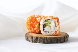 Shrimp sushi rolls. Two sushi rolls with shrimp on wooden plate. Philadelphia, California sushi