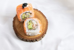 Sushi rolls. Two sushi rolls isolated on wooden plate. Philadelphia, California sushi