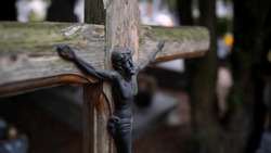 Old Wooden Crucifix on Forgotten Grave in Cemetery