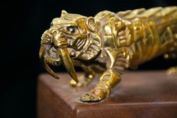 Old small gold tiger Statue in bronze. a fantastic figure made from bronze on black background. Antique bronze culture concept. brozen small statue or bronze sculpture.  tiger side, animal statues