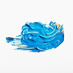 Abstract smear of blue paint mixed with white and gold on white background, macro
