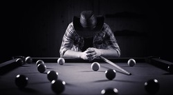 A man with a beard plays a big billiard. Party in 12-foot pool. Billiards in the club game for men. A man with a cue breaks the pyramid.