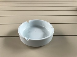 Clean empty round ceramic ashtray on an white table in restaurant.Round ceramic ashtray isolated on wooden background .