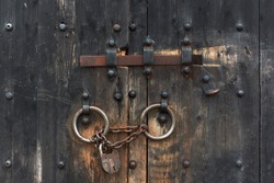 Old gate with a lock on the chain and latch