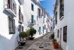 Streets of Frigiliana village. Beautiful white houses and small streets. Typically Andalusian town. Touristic travel destination on Costa del Sol. Vertical photography.   