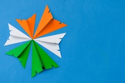 Indian tricolor paper planes arranged in circular shape on blue background. Conceptual image for Indian national day celebration and events. space for text. Top view. 