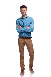 smiling young casual man standing with hands crossed on white backgrouond, full body picture