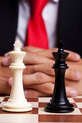 Pair of black and white chess kings in front of businessman