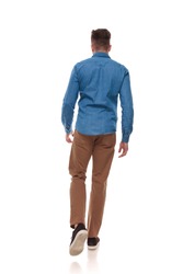 back view of young man in casual clothes walking on white background, full length picture