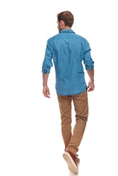 back view of a casual young man walking and looking to side on white background