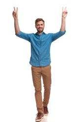 smiling casual man with hands in the air celebrating victory on white background