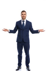 happy businessman in navy blue suit opening arms and smiling, standing and posing isolated on white background in studio