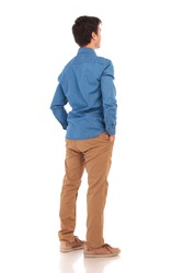 back view of a relaxed casual man with hands in pockets, full body picture of white background