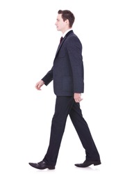 picture of a young business man walking forward - side view