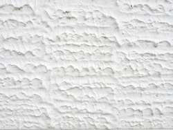 close-up white concrete wall texture background, cement walls are decorated with plastering techniques to have rough surface like cement dripping for decoration exterior facade building wall