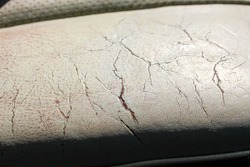 Close up of a heavily worn leather car seat