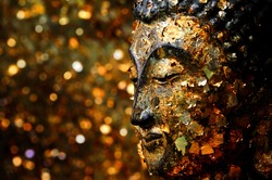 Buddha head filled with gold leaf. Shows the devotion of the Buddhists.
