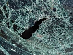 Broken glass texture. Abstract image of shattered glass texture, background. Close-up broken car windshield. Broken and damaged car. Automotive glass or car windshield broken and damage from accident.