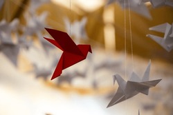 Japanese folded Origami cranes hanging on with strings. Hundreds handmade paper birds isolated with copy space. 1000 thousand crane tsuru sculpture topic. Symbol of peace, faith, health, wishes, hope