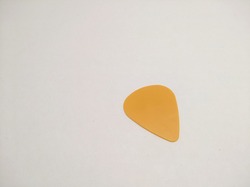 a yellow guitar pick isolated on white
