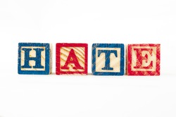 the word HATE formed from cubical wooden letter box. 
