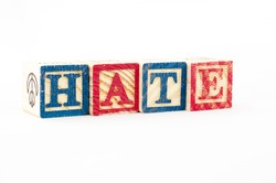 the word HATE formed from cubical wooden letter box. 
